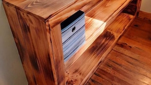 A wooden console table with drawers, positioned against a wall with a power outlet. - 2 Bedroom Cottage 100 yards to water. Dock & Ramp. (Lakeside Marblehead)