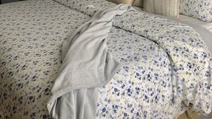 A bedroom with a large bed, a nightstand, a lamp, and a window with curtains. - Charming Edgartown home with wrap around porch (Edgartown)