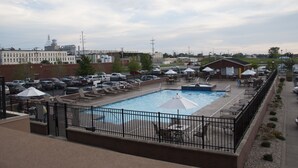 A rooftop pool area with lounge chairs, umbrellas, and a swimming pool. - Upgrade Your Stay...On Sandusky Bay! (Sandusky)