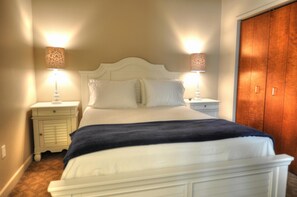 Classic bedroom with a large bed, two bedside tables, and a wooden wardrobe.