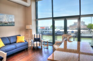 Enjoy a marina view from the comfort of this stylish room, featuring a sofa, armchair, and wicker chair.