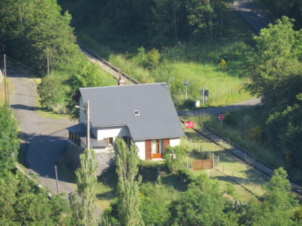 A house with a grey roof, a small porch, and a fenced yard.