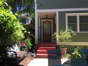 A house with a front porch, a mailbox, and a door with a sign that reads "ROGUE". - Cottage in Historic Irvington neighborhood near Convention Center and shops! (Portland)