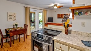 A modern kitchen with a stove, oven, and dining area.