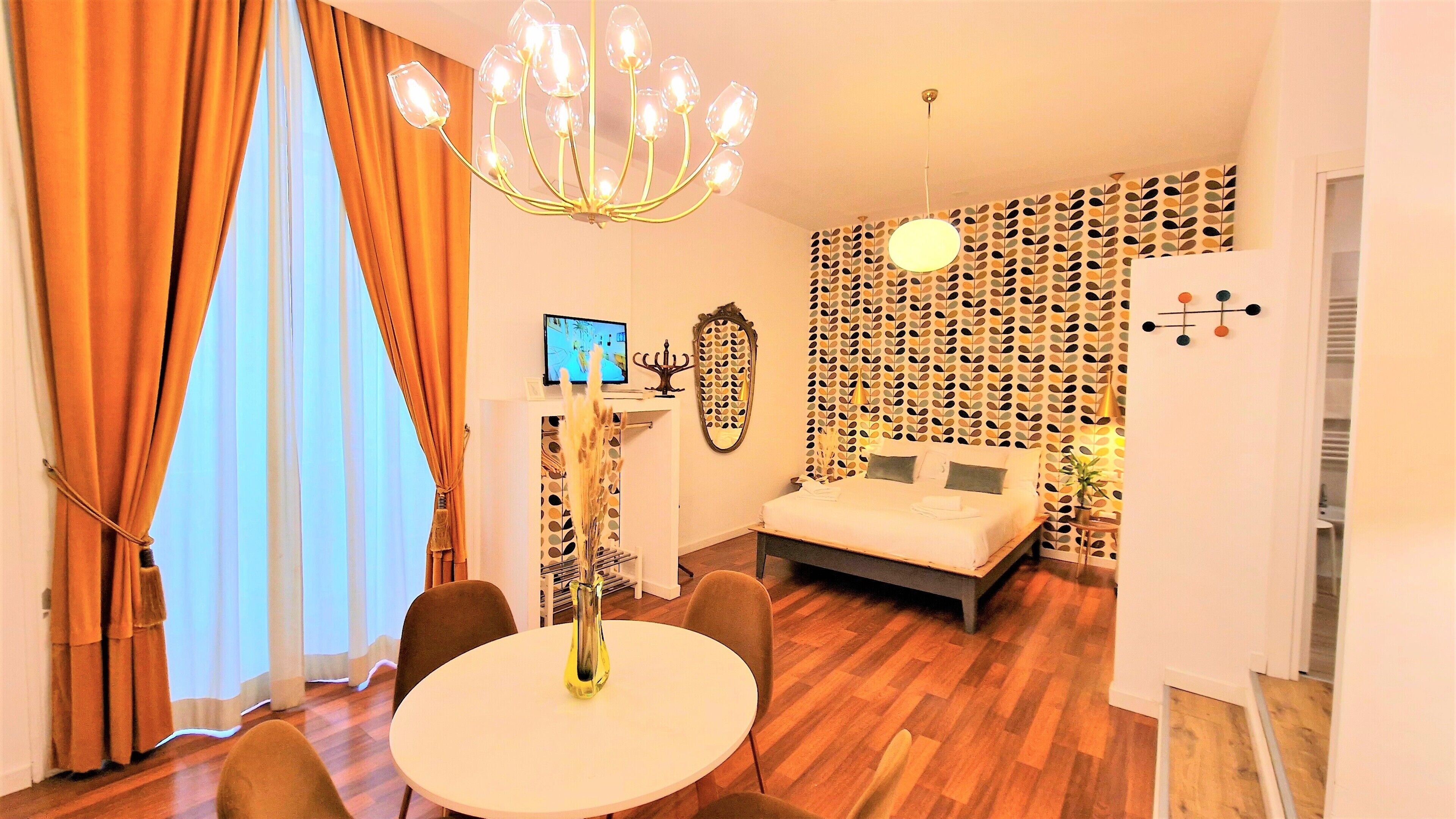 Una habitación de hotel moderna con una cama, una mesa de comedor y un televisor.
