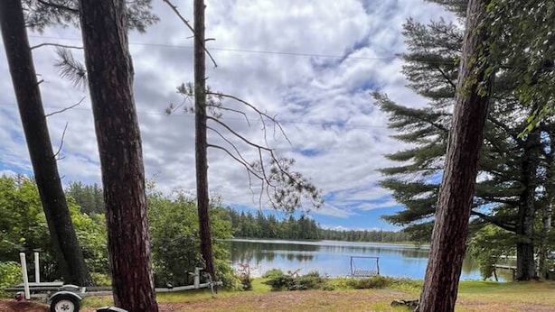Two chairs facing a lake with trees in the background. - Cottage on a Lake.  Near Pictured Rocks/ Munising (Manistique)