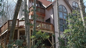A two-story house with a balcony and a large window.