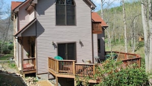 A two-story house with a front porch and a small deck.