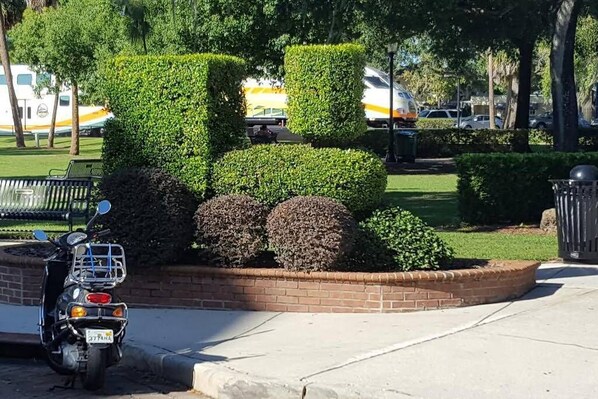 Stroll through the beautifully manicured park, surrounded by a brick wall and lush greenery.