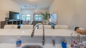 A modern kitchen with a central island, a built-in oven, and a large window.