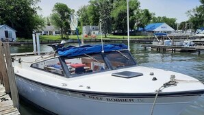 Una barca bianca di nome "PEEF BOBBER" ormeggiata a un molo di legno.