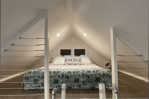 The sleeping loft with comfy queen bed – a serene place to hang out and chill.