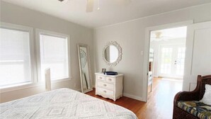 Un dormitorio con una cama grande, un aparador, un espejo y una silla.