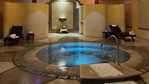 A spa area with a circular hot tub, lounge chairs, and a central chandelier. - Unique Beachfront Penthouse, 2 Bedroom, Sleeps 8, Garden Patio,and TV, Internet  (Nueva Vallarta)