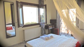 A bedroom with a bed, a desk, a chair, a window, and a radiator. - Vacation Home in Chania,private Pool beachfront , it is consisted of 2 houses.  (Chania)
