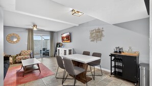 Un salon moderne comprenant un coin repas, un canapé, une table basse et un téléviseur.