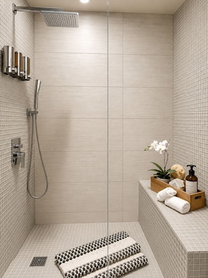 Une douche moderne dotĂ©e dâun pommeau de douche Ă main, dâun panneau de commande mural et dâune petite Ă©tagĂšre pour les articles de toilette.