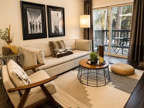 A living room with a sofa, a chair, a coffee table, and two framed pictures on the wall. - Canyon Lodge CHAMONIX Condo. Minutes Walk From Lifts. (Mammoth Lakes)