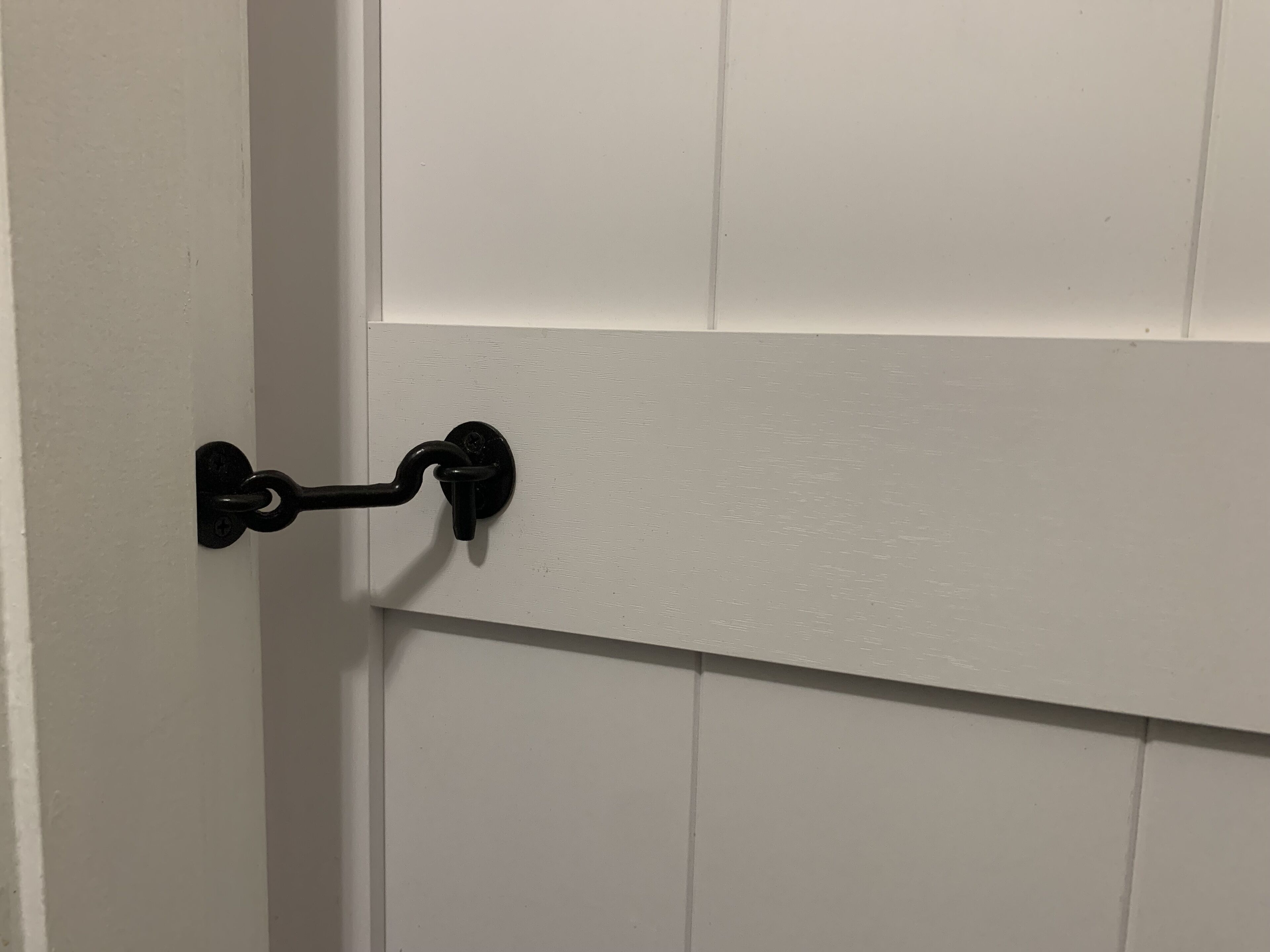 A white door with a black metal handle and a keyhole.