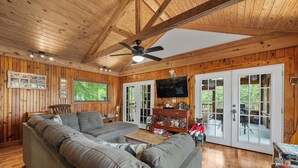 A wooden interior with a sectional sofa, a television, and a dining area. - “Fun” place! — Exceptional" —near Oaklawn Park, Garvin Gardens and Restaurants (Hot Springs)