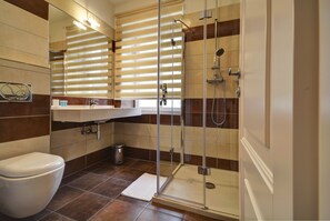 Un baño moderno con inodoro, lavamanos y cabina de ducha con paredes de vidrio.