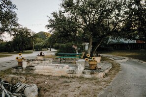 Ein Park mit einer Bank, Blumentöpfen und einem Baum.