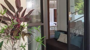 A hotel entrance with a sliding glass door leading to a balcony with a view of the ocean. - Jungle Family Villa in Quepos: Pool, Waterslide & Zipline — Sleeps 6-8 (Parrita)
