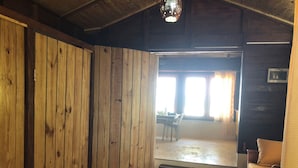 Een houten interieur met een eethoek, een bank en een plafondlamp.