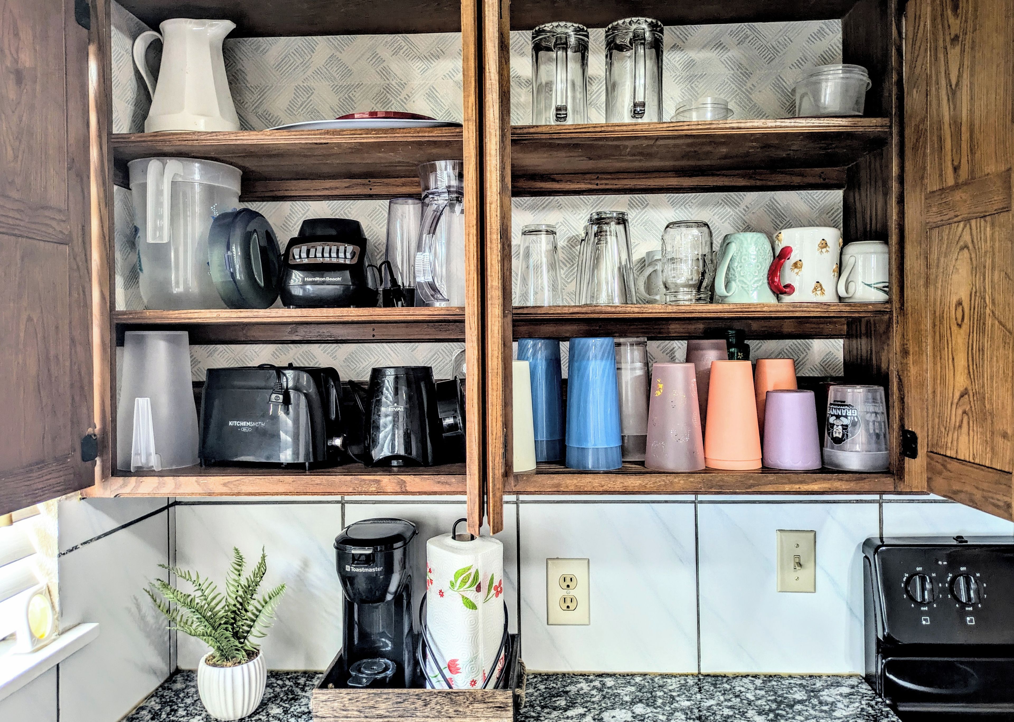 A kitchen with wooden shelves holding various kitchenware, a toaster, and a coffee maker.