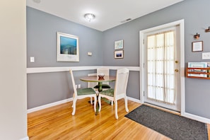 A dining area with a round table, two chairs, and a door with a glass panel. - Stay and Play @ Railway Rest, near AVL, trails, falls (Old Fort)