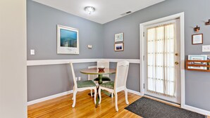 A dining area with a round table, two chairs, and a door with a glass panel. - Stay and Play @ Railway Rest, near AVL, trails, falls (Old Fort)