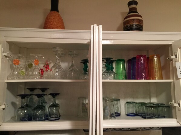 A kitchen cabinet with wine glasses and bottles. - Quiet and serene ocean front 2-bedroom 2-bathroom condo, steps from the sand! (Puerto Morelos)