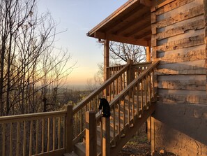 A wooden staircase leading to a cabin with a view of a forested landscape. - HONEYMOON HIDEAWAY - SECLUDED ANTIQUE LOG CABIN WITH AMAZING VIEWS!!! (Gatlinburg)