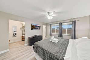 A bedroom with a bed, a dresser, a ceiling fan, a window with curtains, and a painting on the wall. - Old Town Scottsdale Home Centrally Located with Private Pool/Patio (Scottsdale)