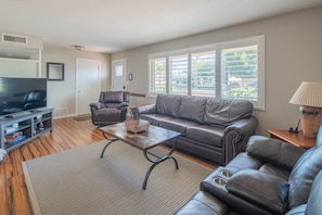 Relax in this stylish living room with a comfortable sofa, flat-screen TV, and large window.