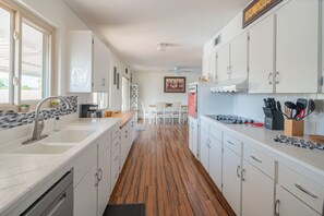 Kitchen features a large sink, refrigerator, and ample counter space for food preparation.