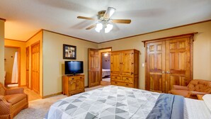 A bedroom with a large bed, wooden wardrobe, a television on a wooden cabinet, and a ceiling fan. - Quaint, Spacious, And Minutes From Everything You Want To See In Chattanooga (Chattanooga)