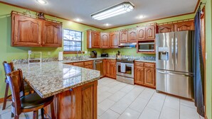 A kitchen with wooden cabinets, granite countertops, stainless steel appliances, and a window providing natural light. - Quaint, Spacious, And Minutes From Everything You Want To See In Chattanooga (Chattanooga)