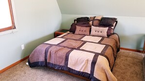 A bedroom with a bed, a nightstand, and a window. - Large Brighton area studio  (Brighton)
