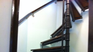 A wooden staircase with a handrail and a dark finish. - RIVERKEEPER INN, Waterfront Property on the Potomac River   (Harper's Ferry)