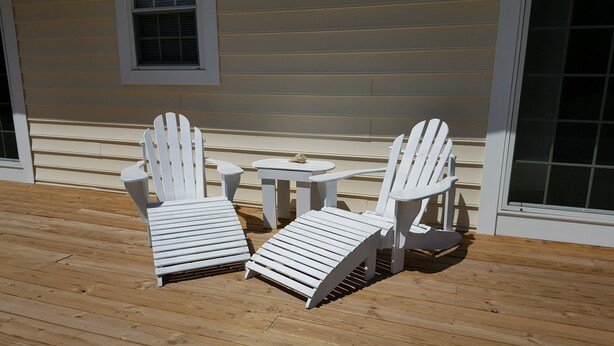 A deck with two Adirondack chairs and a small table. - Quiet convenient location! Remodeled 4br 3ba. Dog friendly, huge deck, hot tub . (Ocean View)