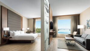 Un hotel moderno con una cama grande, un sofá, un escritorio y vistas al océano.
