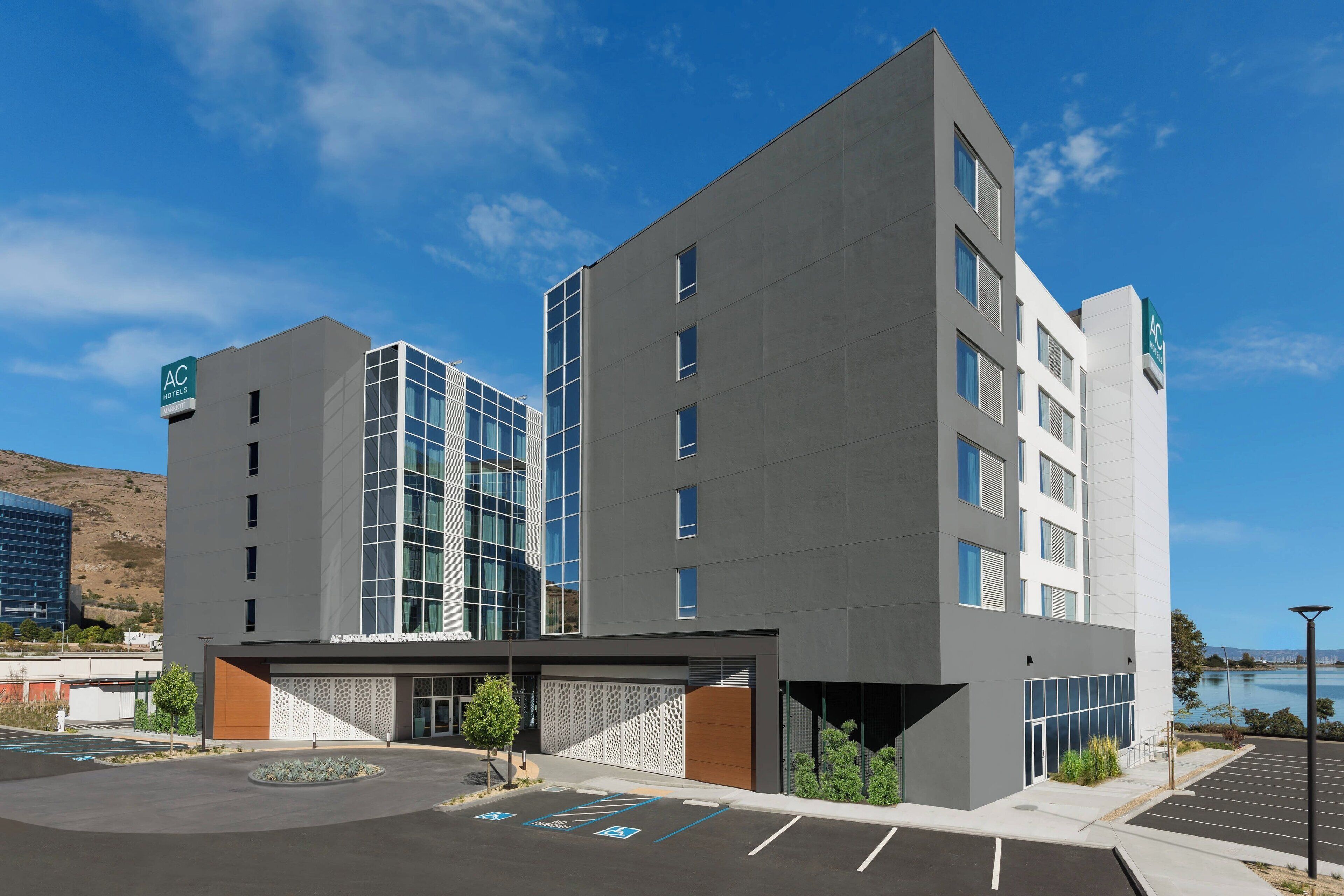 Un hôtel moderne doté d’un toit plat, de grandes fenêtres et d’un parking.