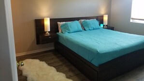 A bedroom with a bed, two bedside lamps, a nightstand, a fluffy white rug, and a window. - Downtown Pagosa Springs, within walking distance to everything (Pagosa Springs)