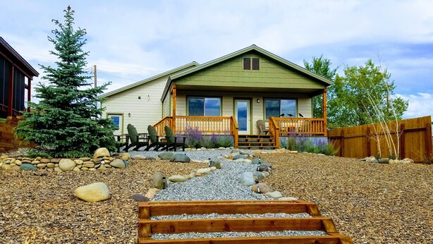 A house with a front porch, a wooden staircase leading to the entrance, and a garden area with rocks and plants. - Downtown Pagosa Springs, within walking distance to everything (Pagosa Springs)