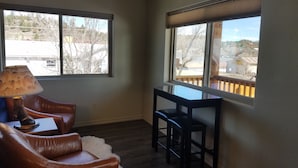 A room with a large window, a leather chair, a small table, and a lamp. - Downtown Pagosa Springs, within walking distance to everything (Pagosa Springs)