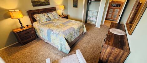 A bedroom with a bed, nightstands, a dresser, a chair, and a closet.