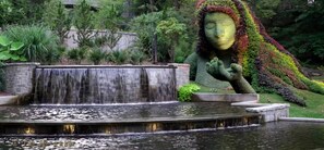 Un jardín con una cascada y una estatua.