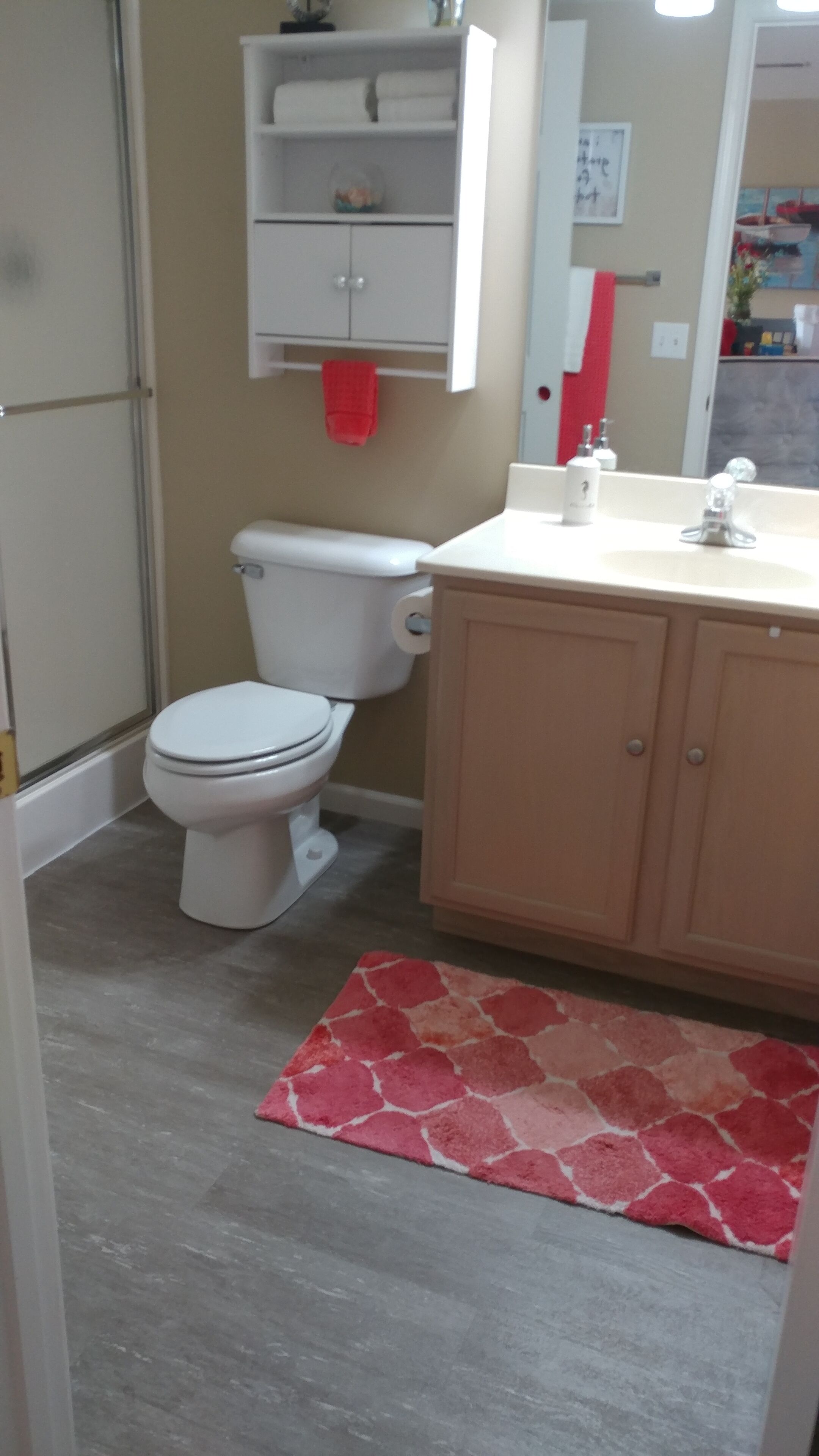 Une salle de bain avec des toilettes, un lavabo et un meuble de rangement.