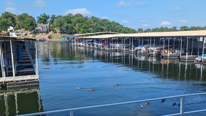 A waterfront dock with boats, a bench, and a clear sky.